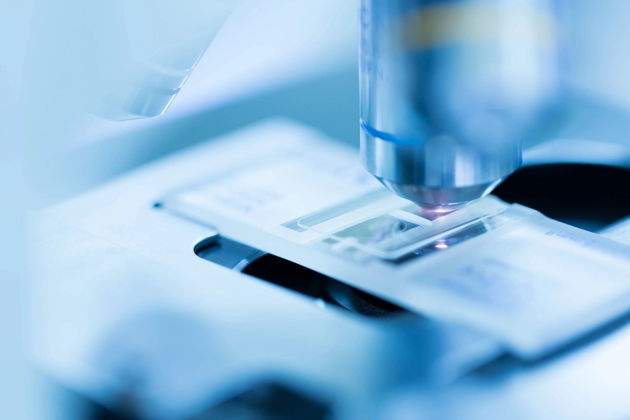 A microscope is shown with some papers on top of it.